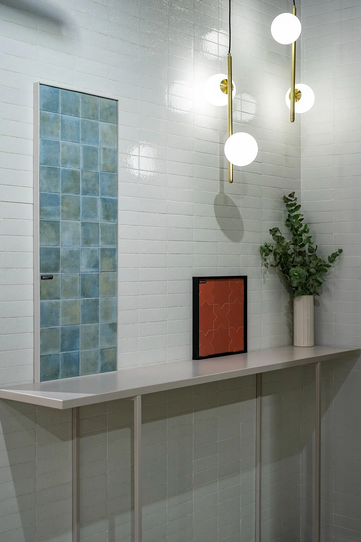 Rincón de stand en Cersaie 2023 con panel de azulejo azul y lámparas doradas
