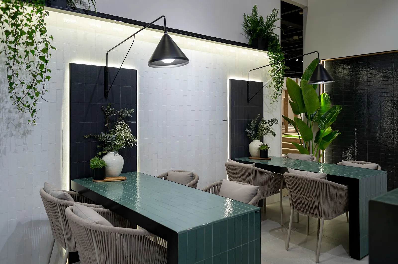 Zona de reuniones en Cevisama 2024 con mesas alicatadas en verde